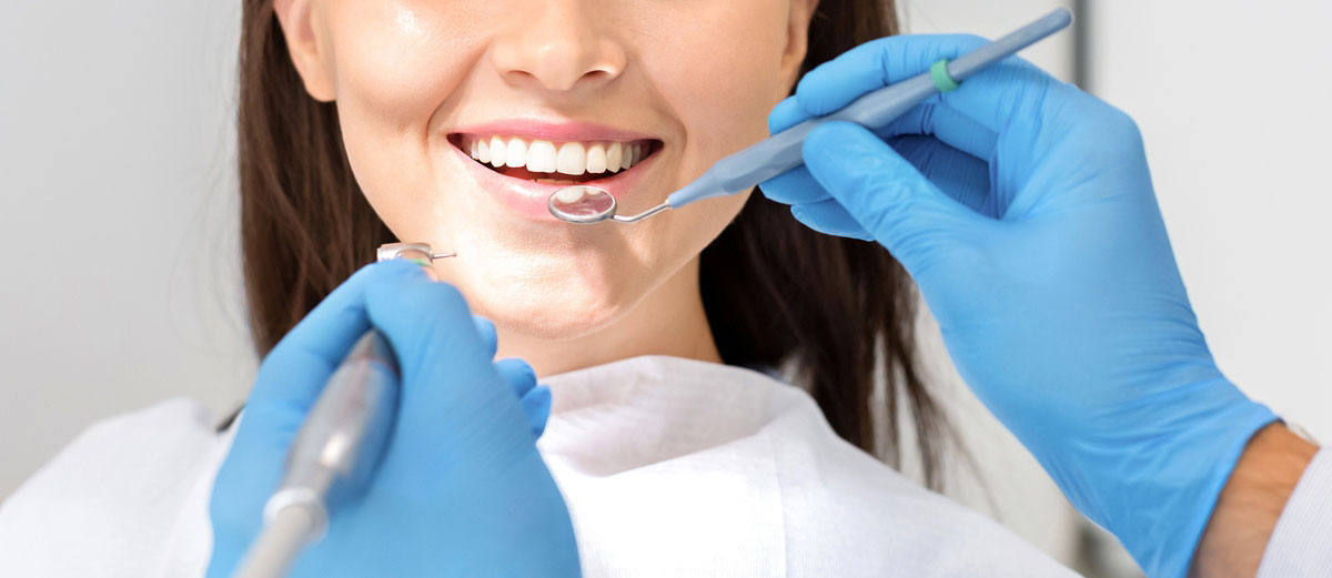 Woman receives a dental cleaning at a cosmetic dentistry clinic in Palm Desert, CA